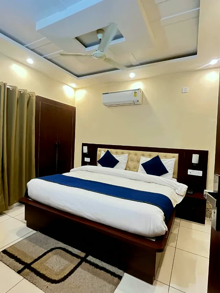 A guest room with a dark wardrobe beside the bed.