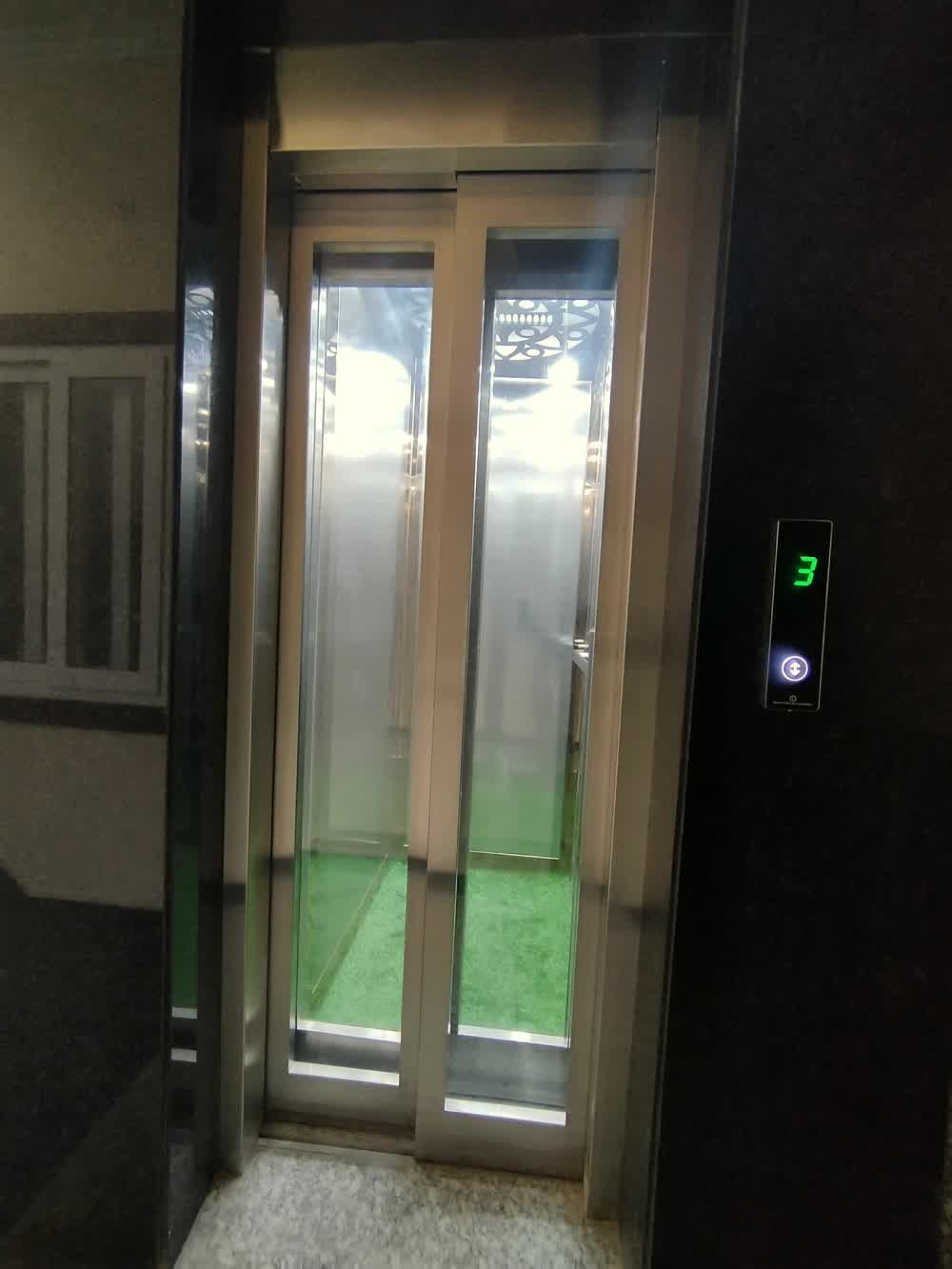 The lift on a guest floor, its indicator showing the third.
